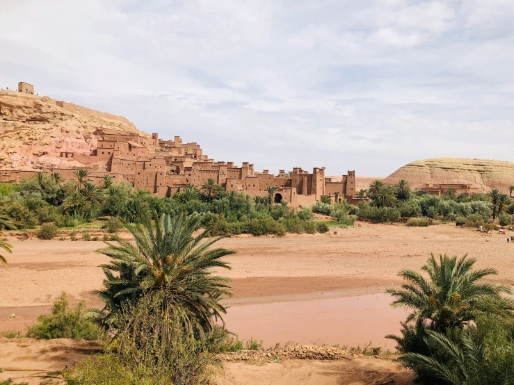 a small desert town with a river near the mountains