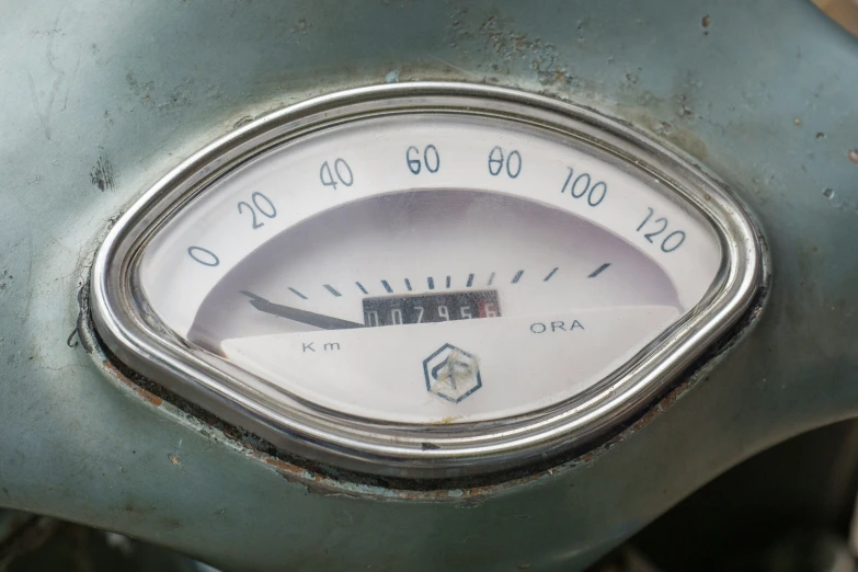 an old blue motorbike has an analog timer