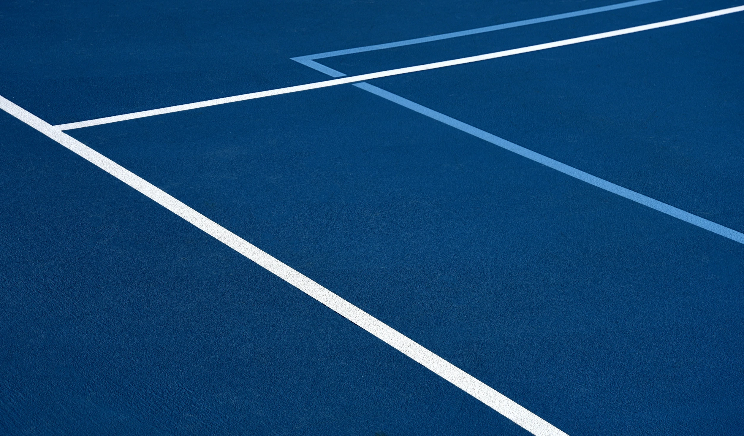 a tennis court is blue and has white lines