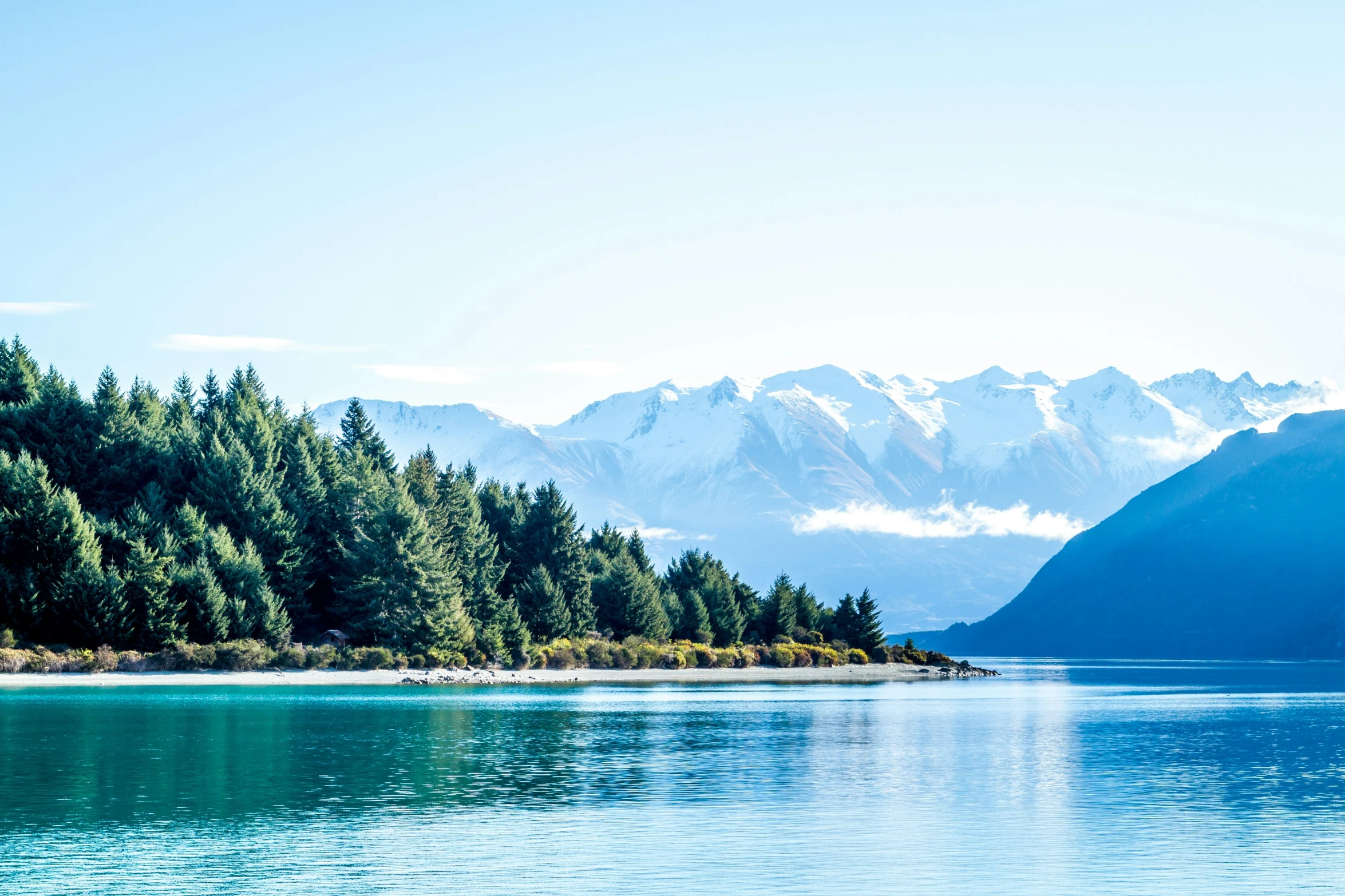 a view of the mountains from the water of a lake