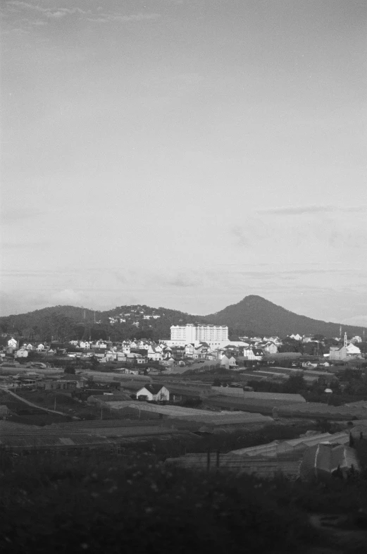 some buildings and hills and clouds in the sky