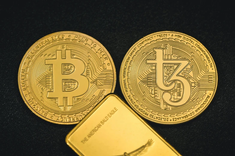 three bitcoins sit side by side next to one another