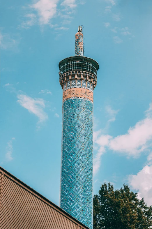 a tall tower in a small field next to a brick wall