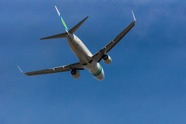 an airplane flying in the air on a bright sunny day