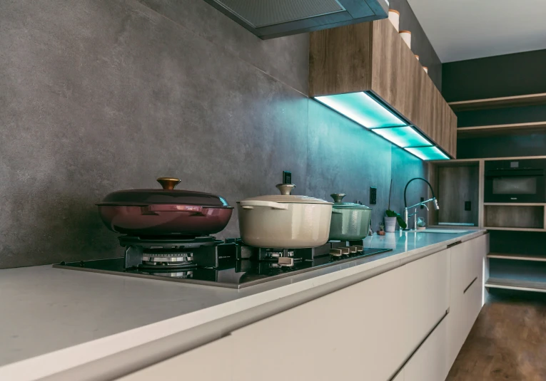 a large kitchen with white cabinets and a blue lighting