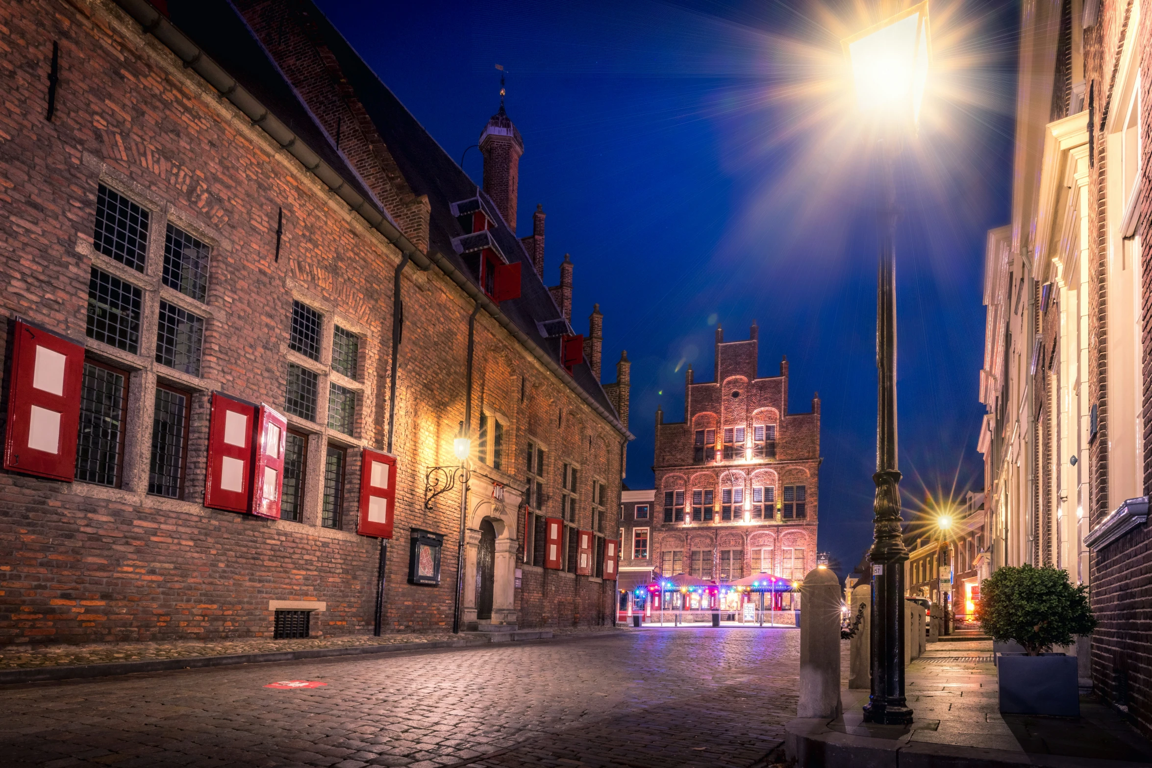 a night time s of a bricked street with lights on