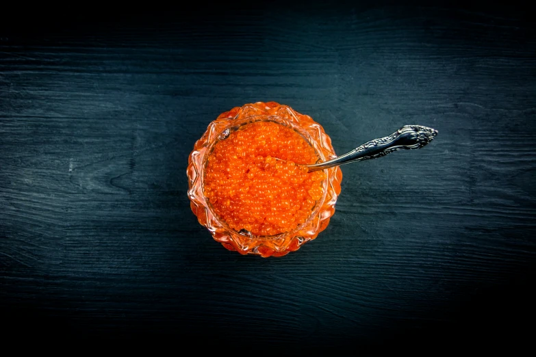 an orange, with a black fork, on a table