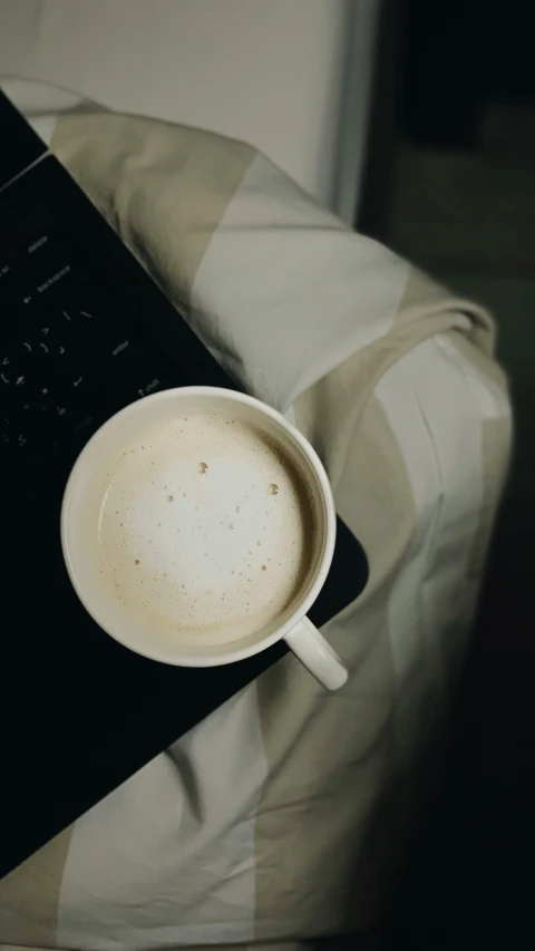 a close - up of a coffee mug on a laptop keyboard