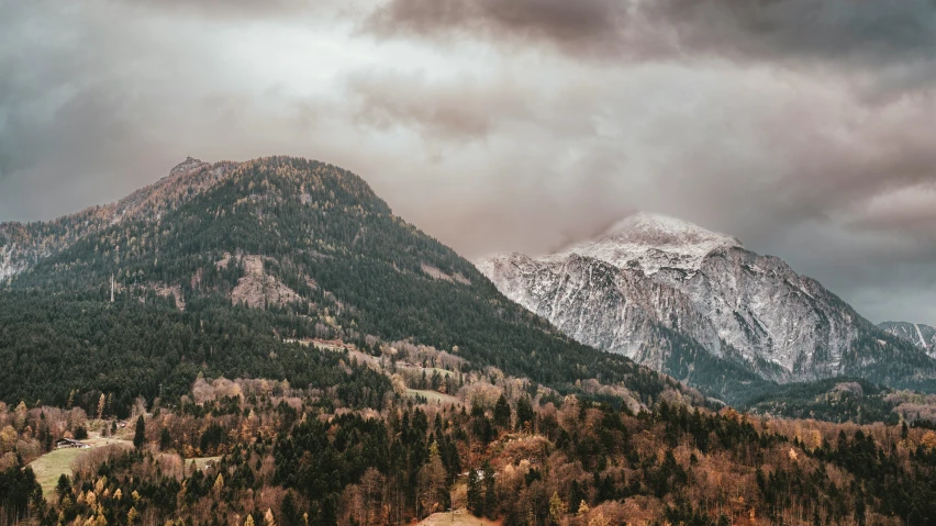 some hills with snow on them and green trees