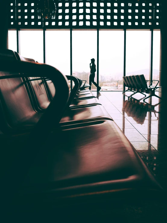 the silhouette of a man is seen through the airport window