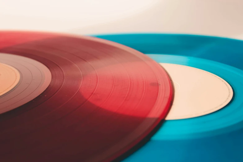 three colored records on white and red, each with a single vinyl album