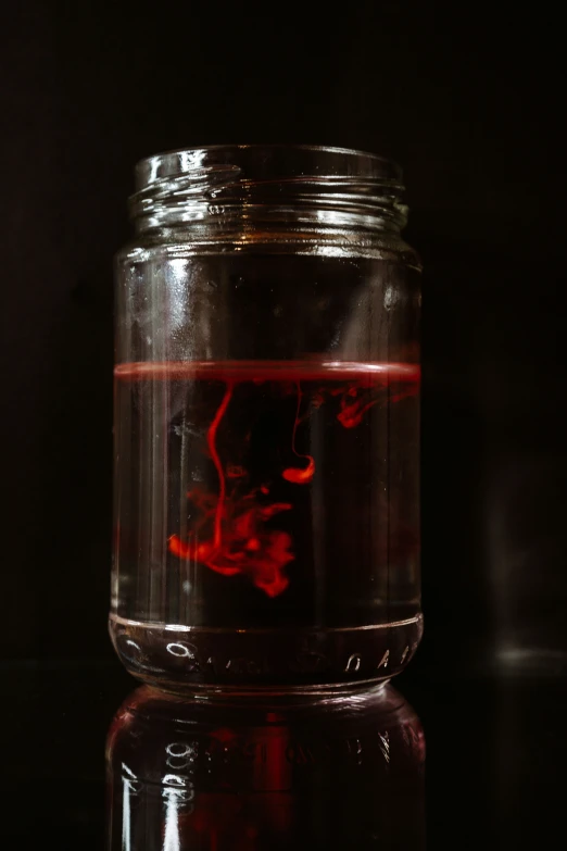 a jar with liquid inside of it on top of a table