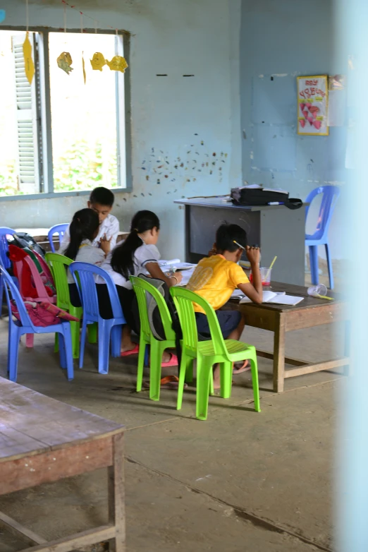 girls are at a desk in an empty classroom