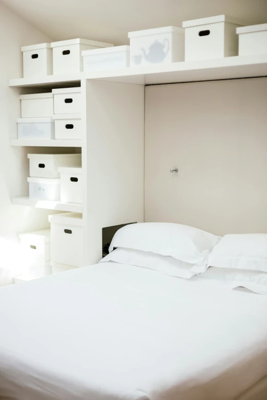a white bed with lots of boxes on it