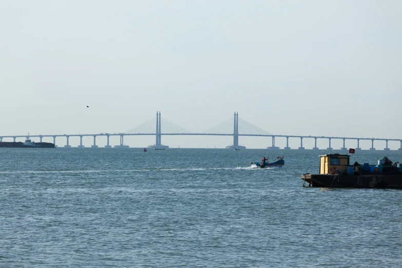 people on a small boat heading towards a large bridge