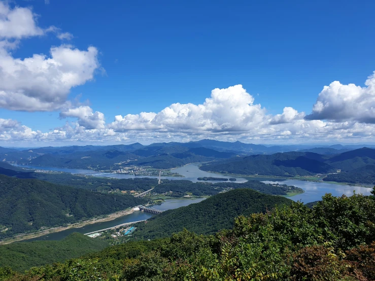 the view over a valley with a lake surrounded by mountains