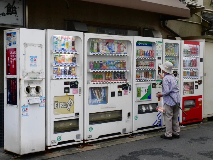 a man is standing next to two vending machines