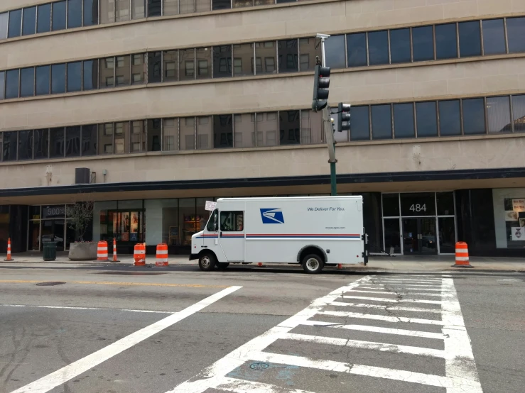 the delivery truck is parked at the corner of the street