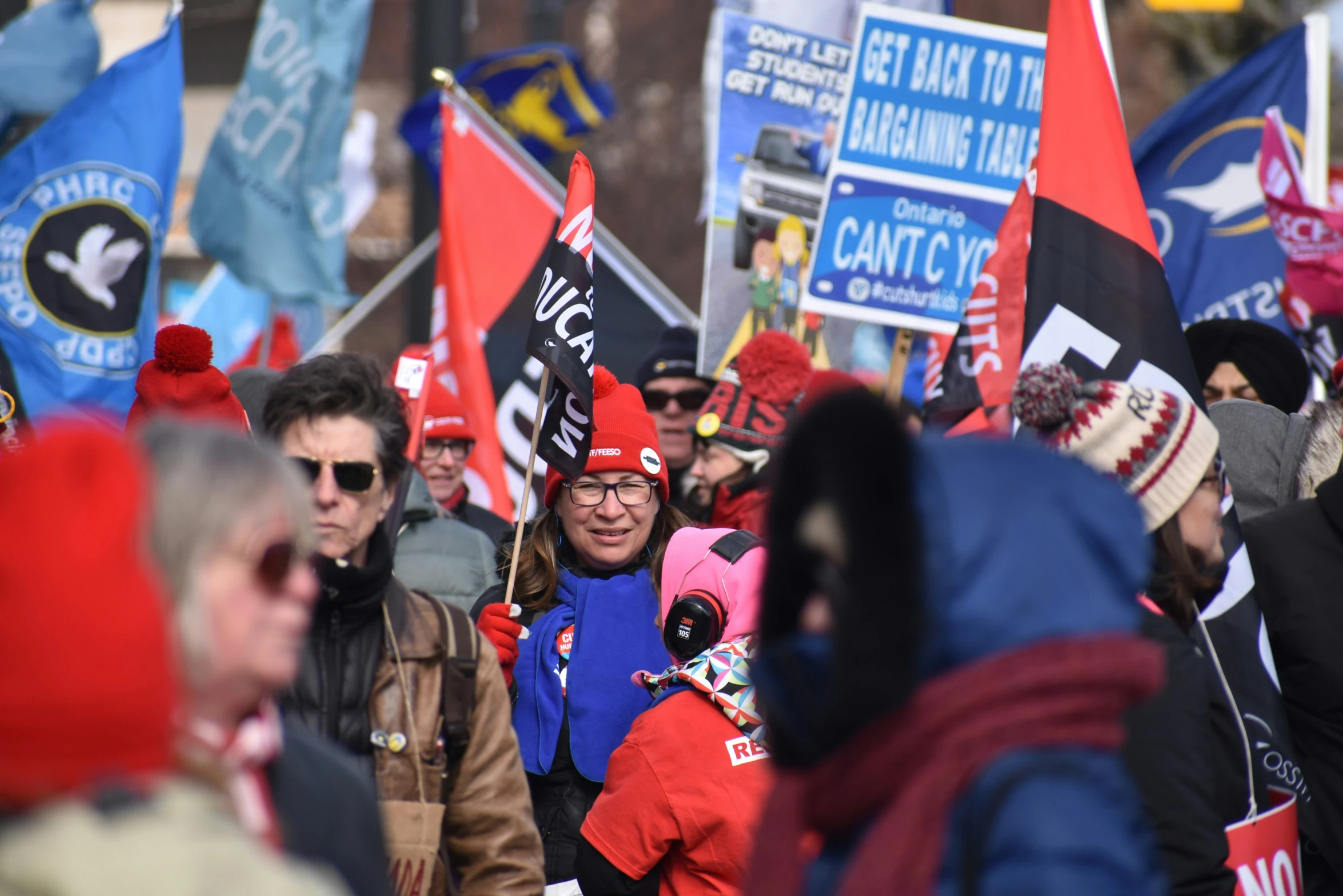 a woman holding a sign among a crowd of people