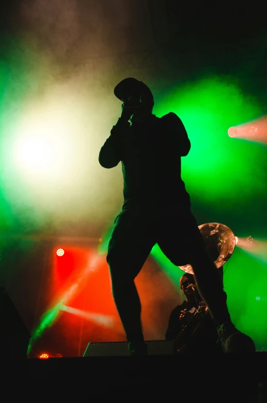 a man standing on stage while he talks on the phone