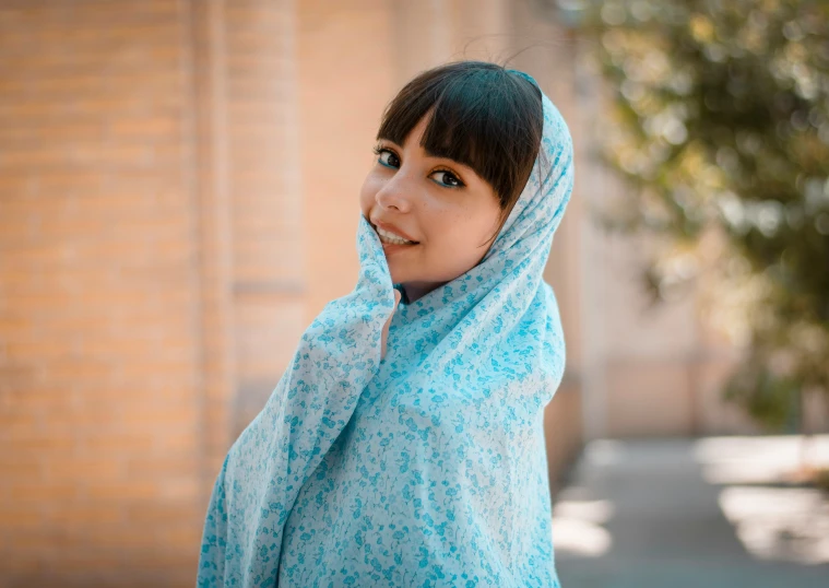 a woman with a headscarf has a smirk on her face