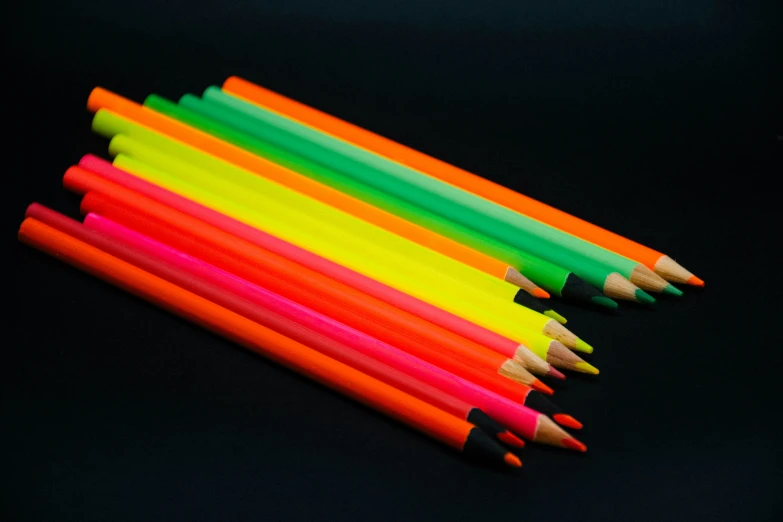 some yellow and orange pencils on a black table