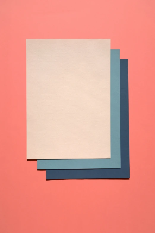 blue and white paper sit side by side on a pink surface