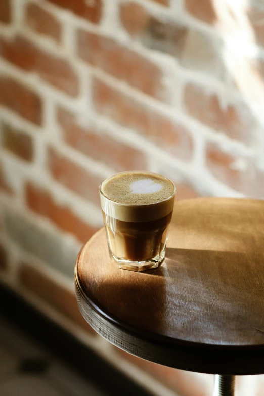 an espresso with a foamy cap on a wooden table