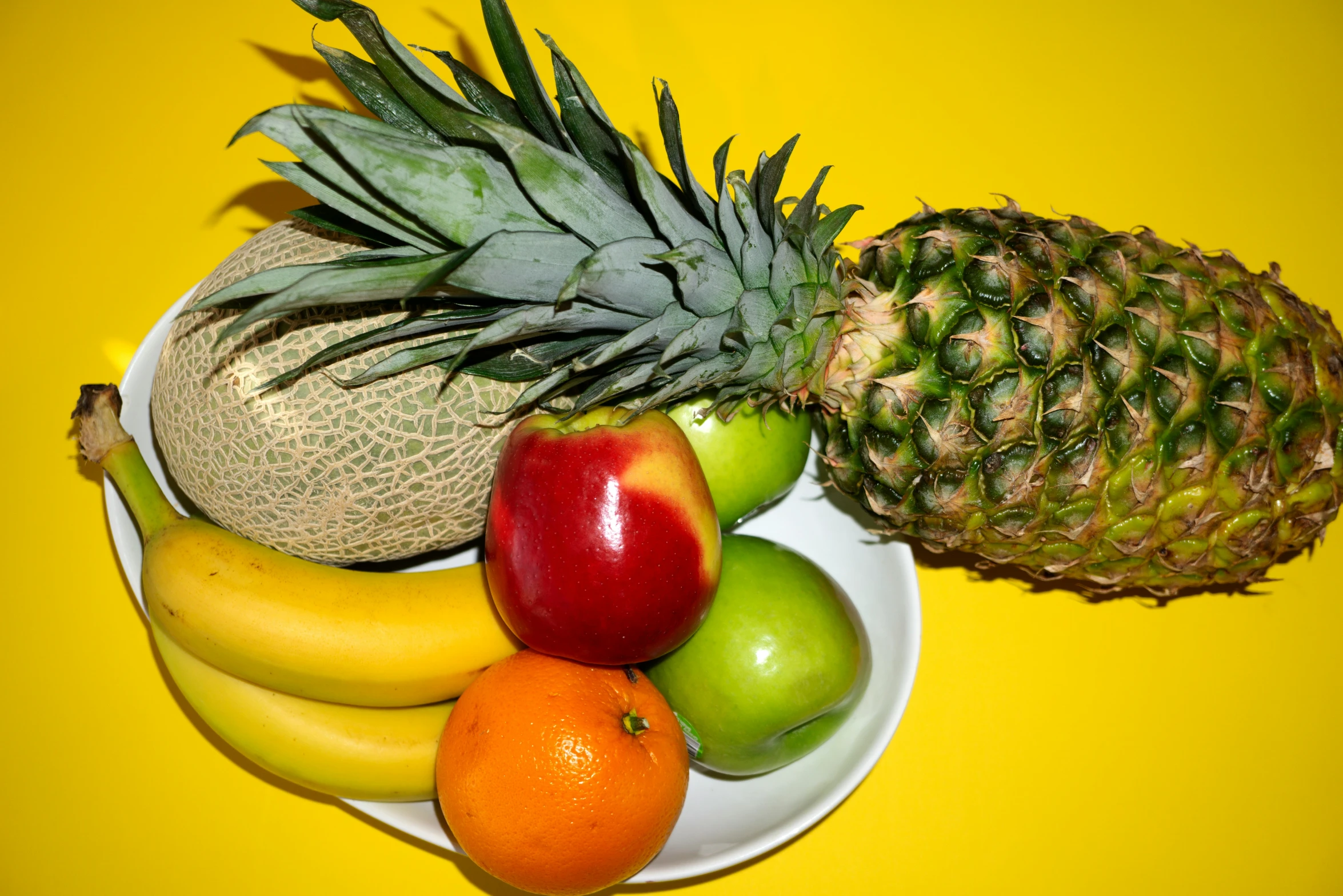 an arrangement of fresh fruits including bananas, apples, and other fruit