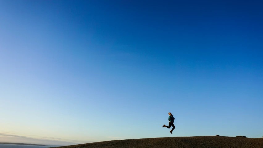 a woman running up a hill during the day