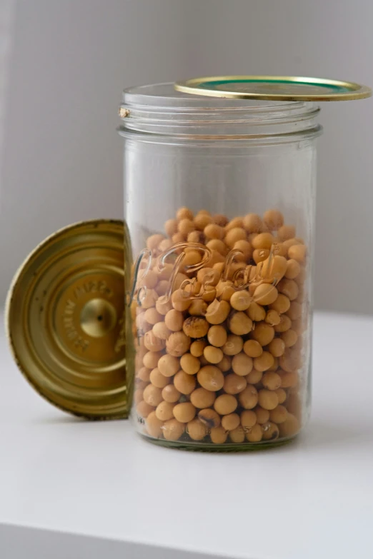 a jar full of nuts sitting on top of a white shelf