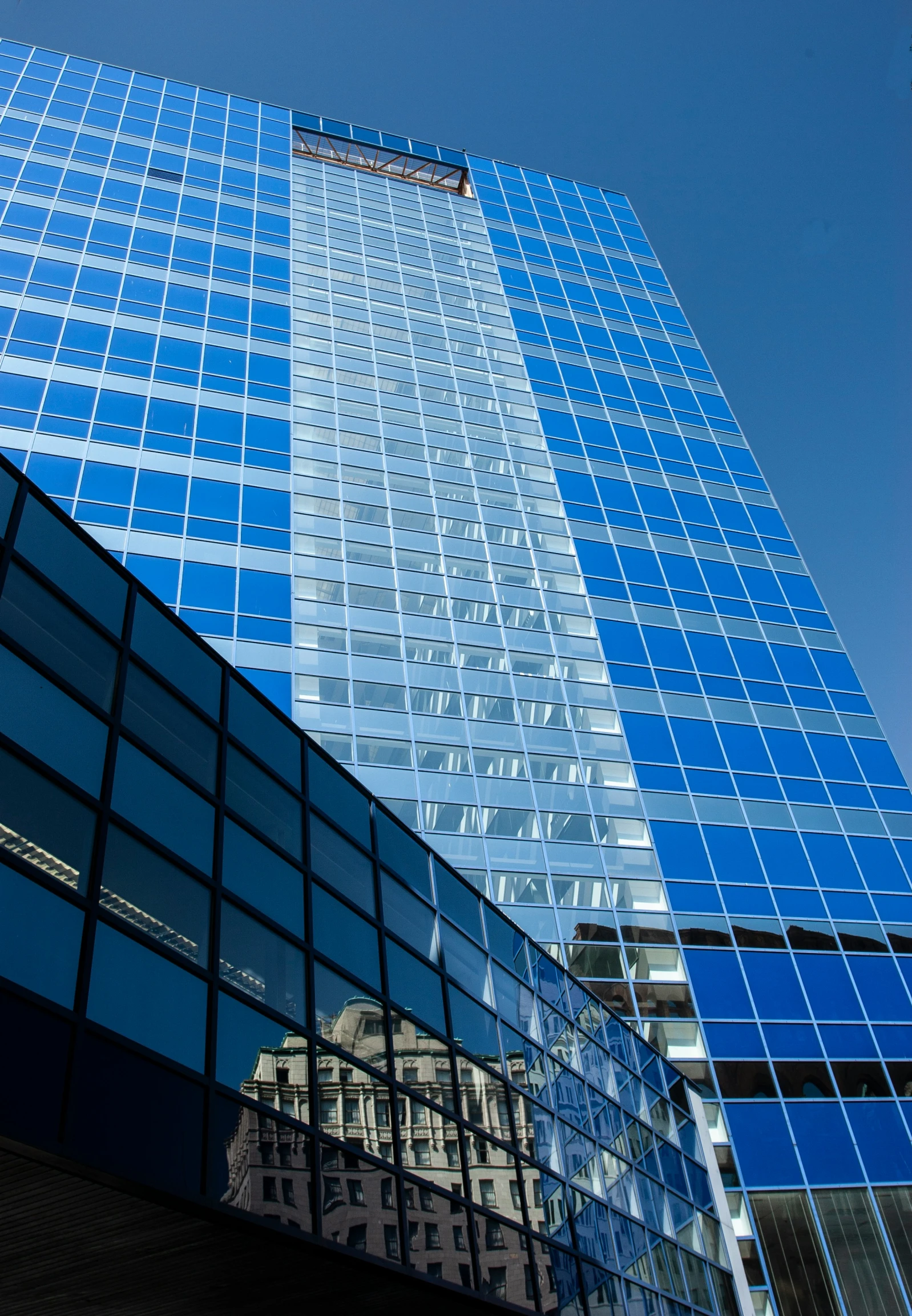 the view of a large building in front of another blue skyscr