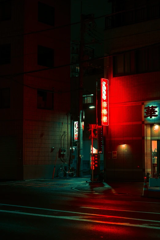 the intersection of a dark street has a building lit up