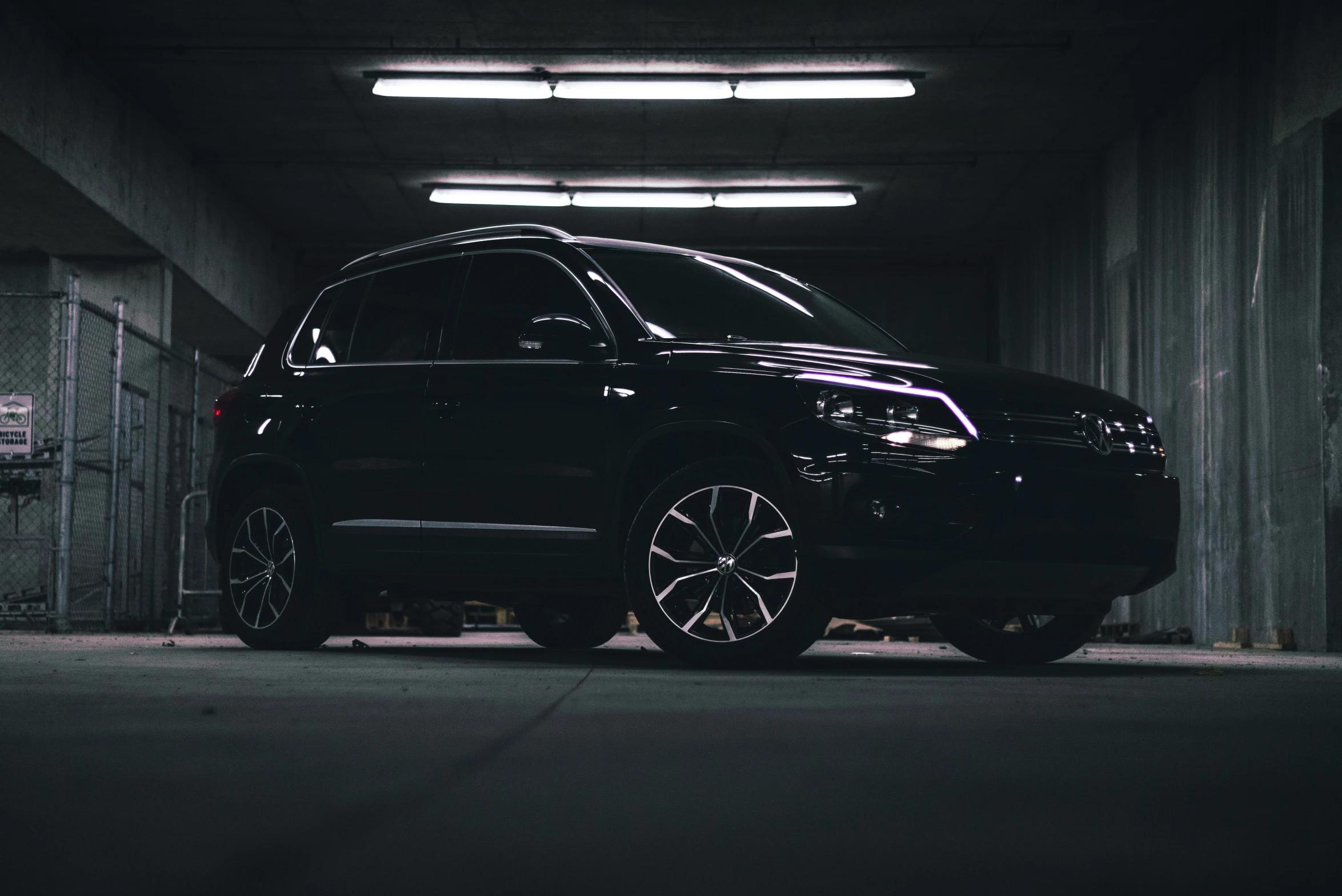 a black suv is parked inside a dark tunnel