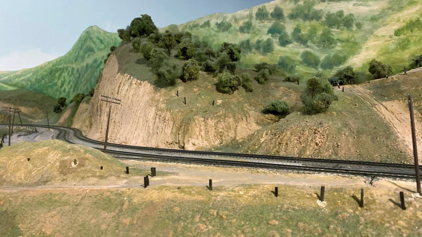 a landscape view showing a train track with trees and mountains in the background