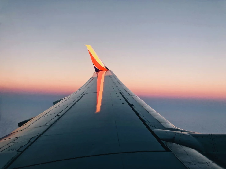 view of the wing from inside an airplane at sunset