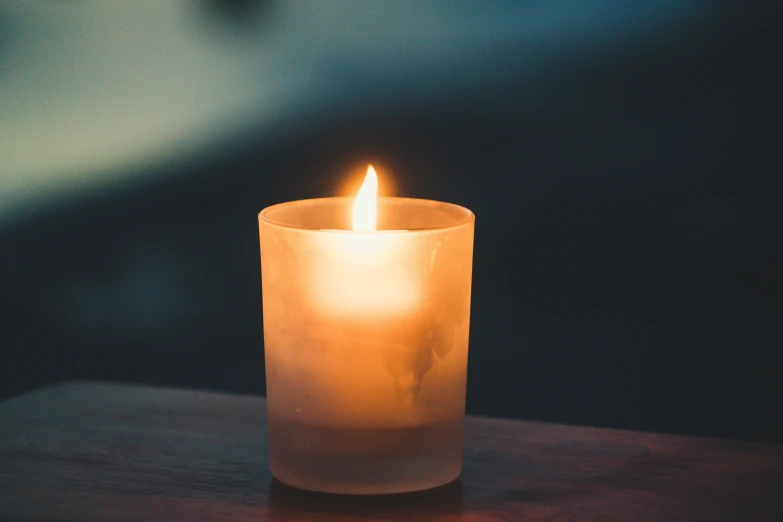 lit candle sitting on top of a table