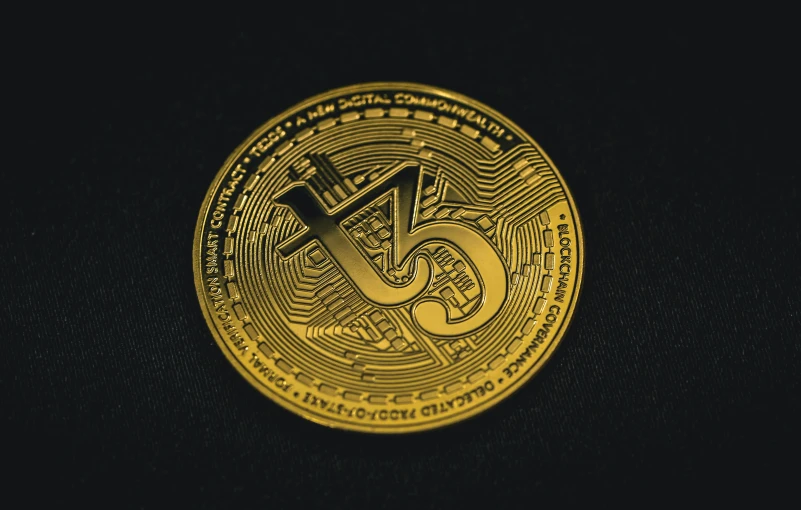 a gold coin sitting on top of a black surface