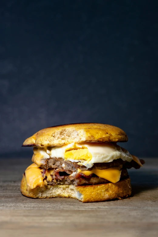 an egg and cheese breakfast sandwich with a bite taken out of it
