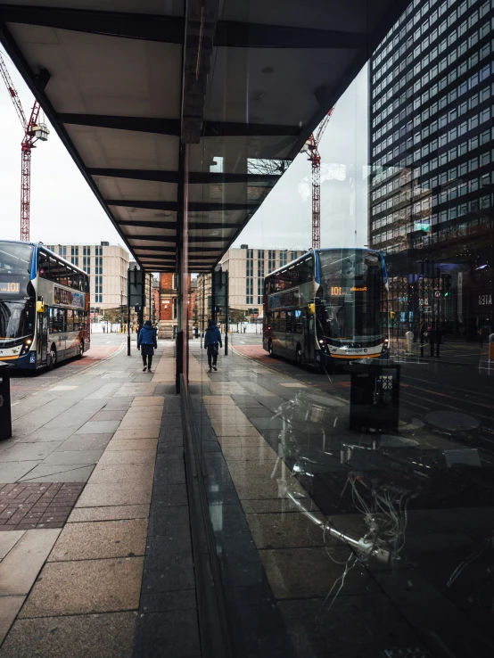 some buses are parked by the road and some buildings