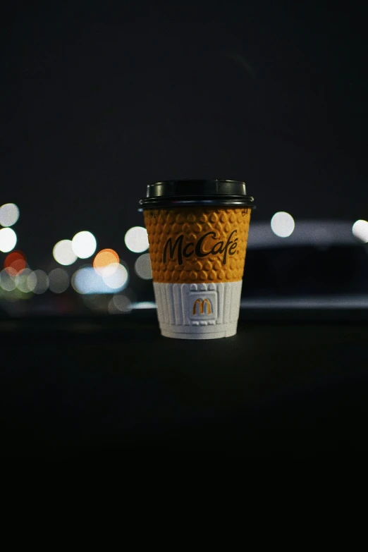 starbucks cup sitting on table in dark lit area