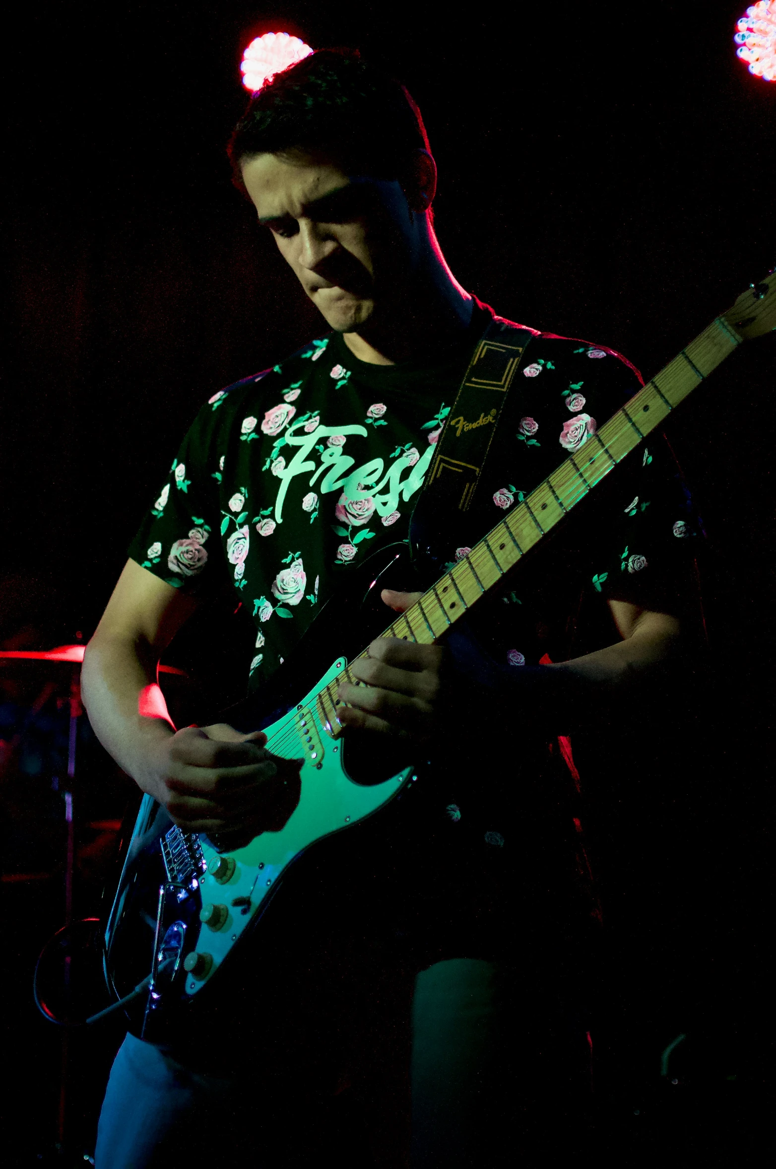 a man with a guitar playing on a stage