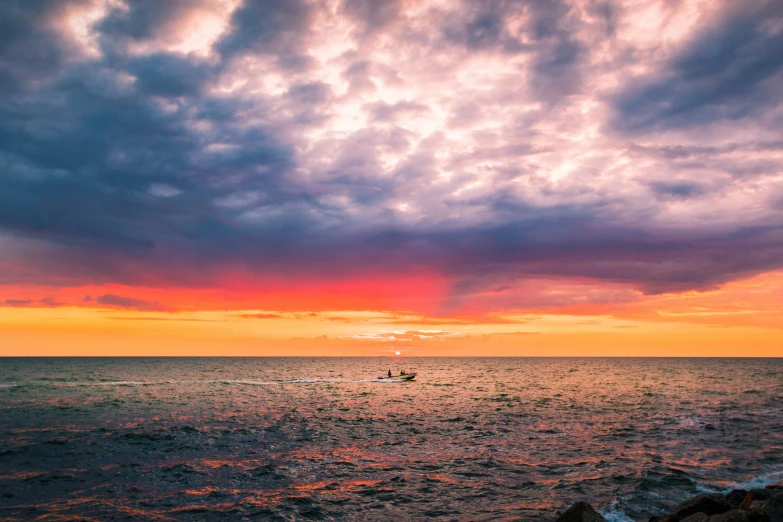 boat sailing in the ocean during a pretty sunset