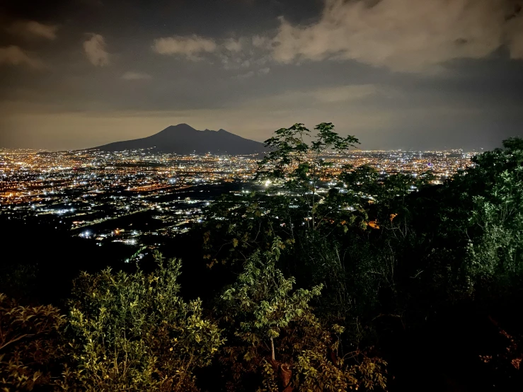 night view of city lights from top of mountain with cloudy sky