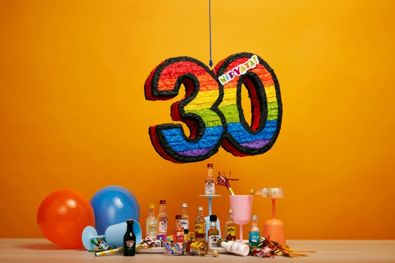 a banner with a number surrounded by confetti, balloons, and bottles