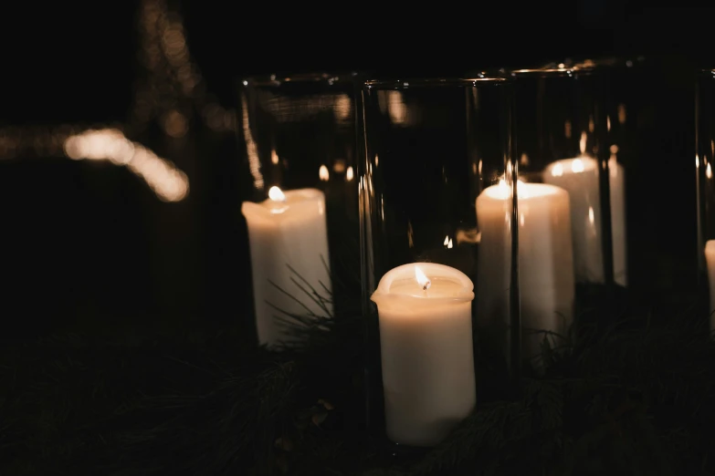 a row of burning candles that are lined up against each other