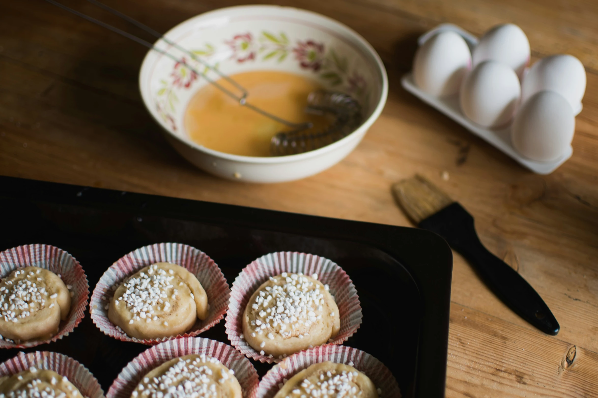 a batch of white chocolate cookie cups on a table next to an egg container