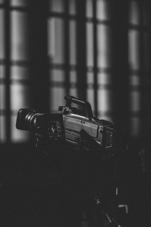 an old camera sitting on a table next to a window