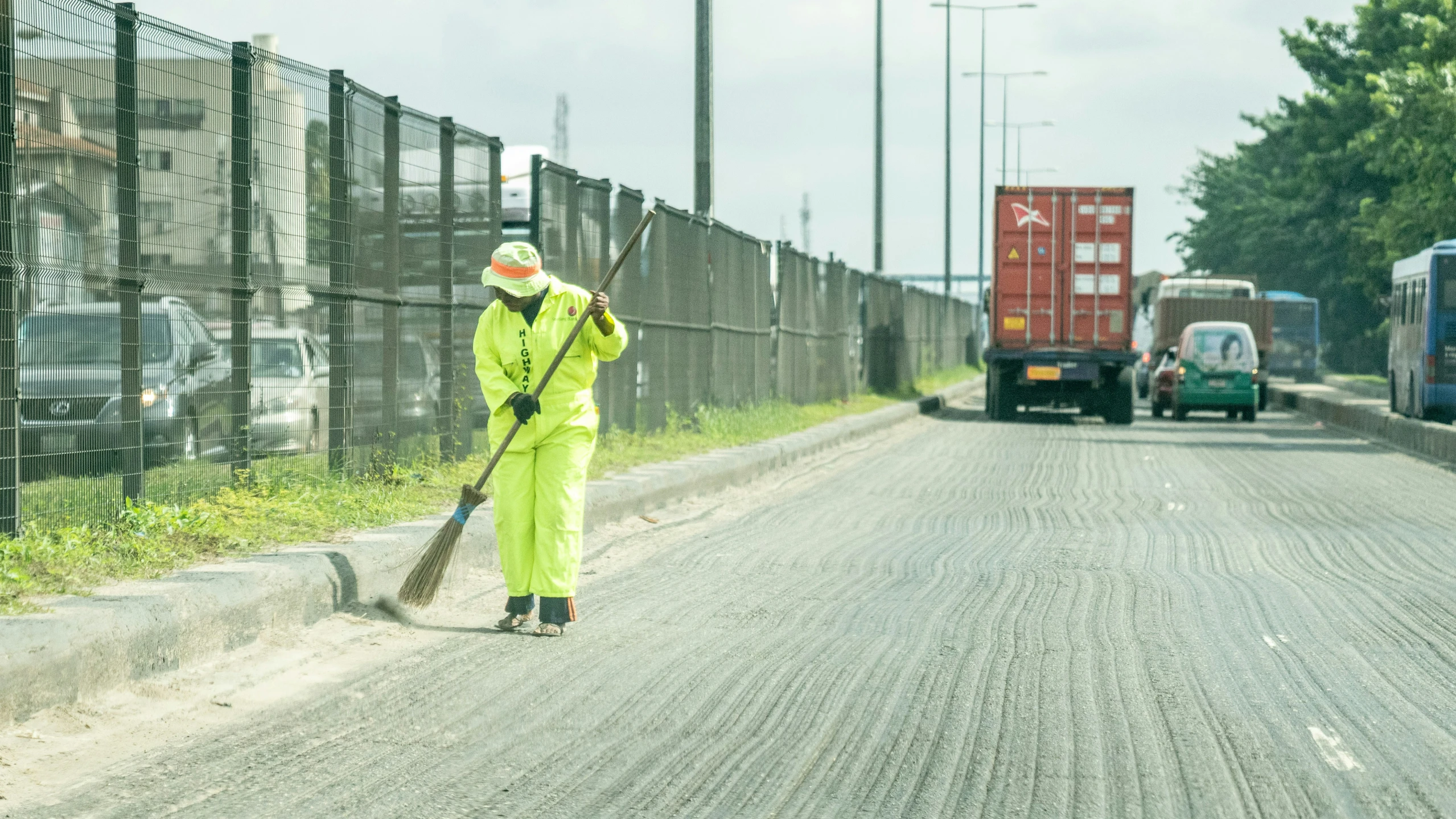 a person in a yellow suit and mask cleaning the street