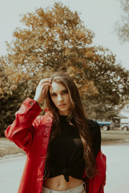 a woman with long hair wearing a red jacket posing for a pograph